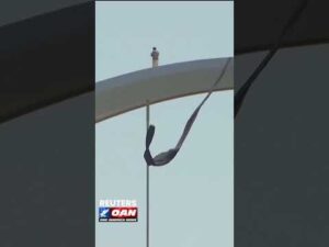 Protester sits atop Washington, D.C.'s Frederick Douglass Memorial Bridge as he reaches day four