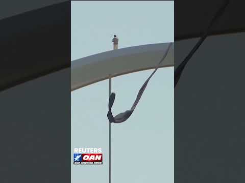 Protester sits atop Washington, D.C.'s Frederick Douglass Memorial Bridge as he reaches day four